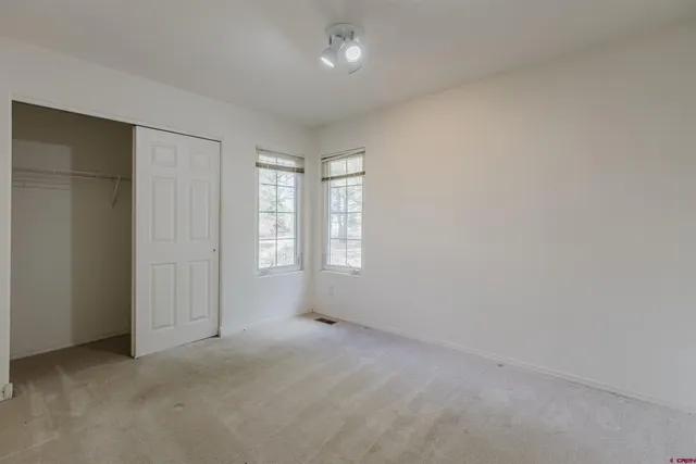 an empty room with windows and closet