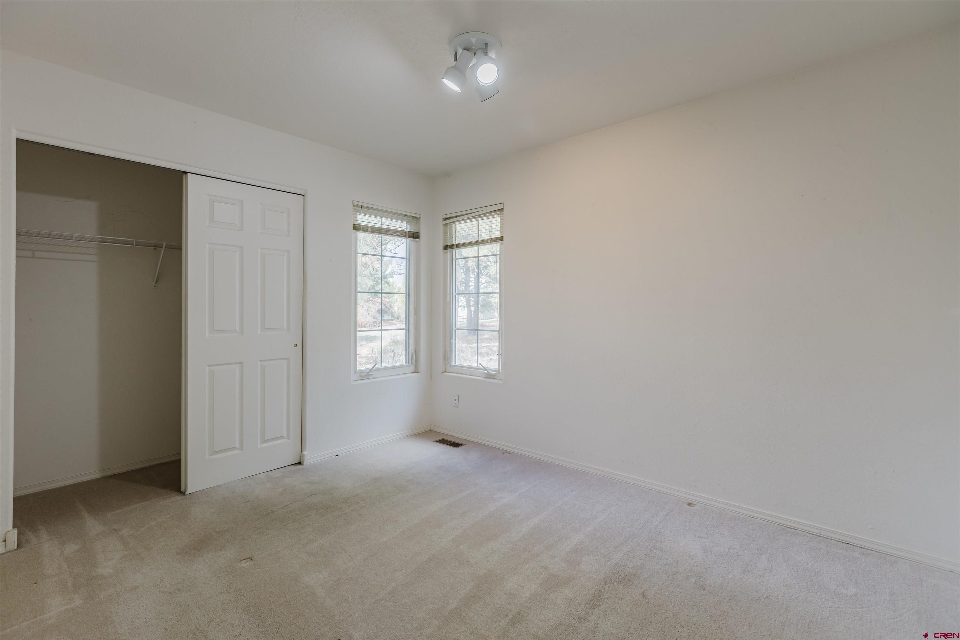 285 Beaver Circle Pagosa Springs, CO 81147 - Photo 32 of 42 an empty room with windows and closet