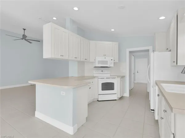 a kitchen with white cabinets and white appliances