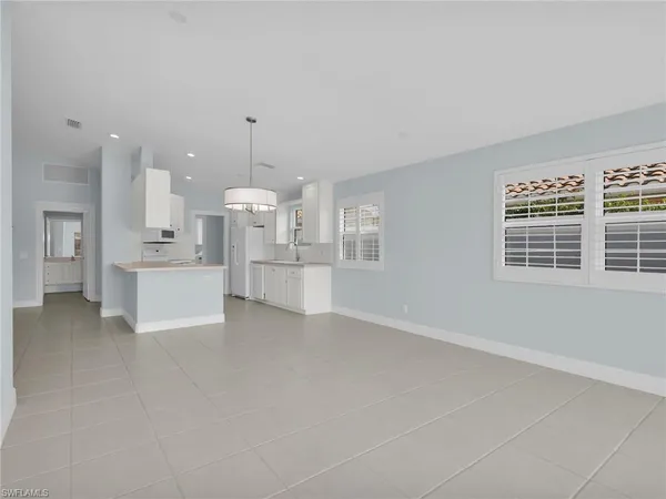a view of a kitchen with white cabinets and stainless steel appliances