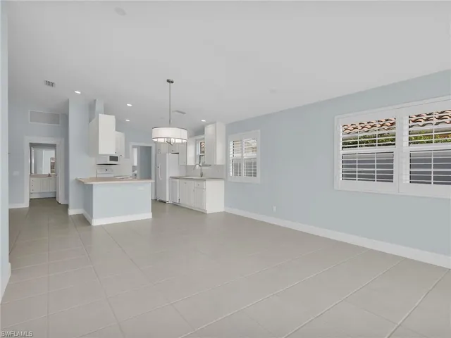 a view of a kitchen with white cabinets and stainless steel appliances