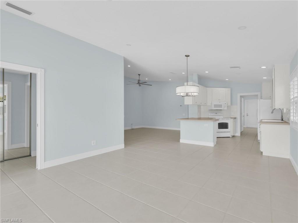 4231 Redonda Lane Naples, FL 34119 - Photo 16 of 42 a view of a kitchen with white cabinets and stainless steel appliances