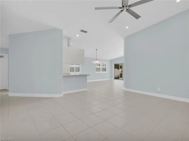 an empty room with kitchen view and a window