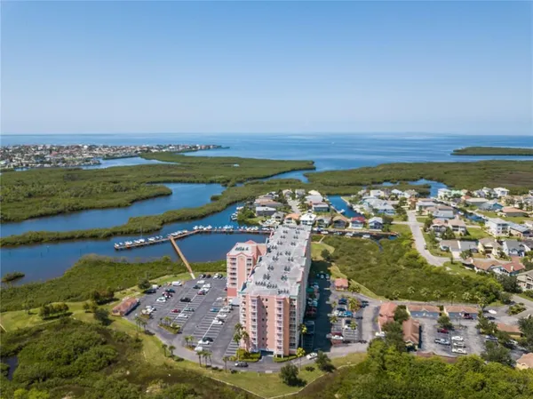an aerial view of ocean and residential houses with outdoor space