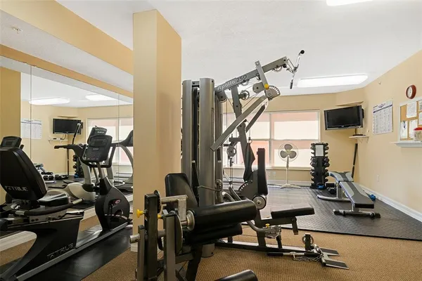 a room with gym equipment and a flat screen tv