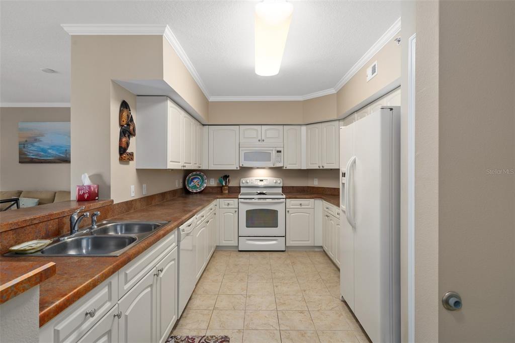 4516 Seagull Drive, Unit 810 New Port Richey, FL 34652 - Photo 30 of 54 a kitchen with a sink stove and cabinets