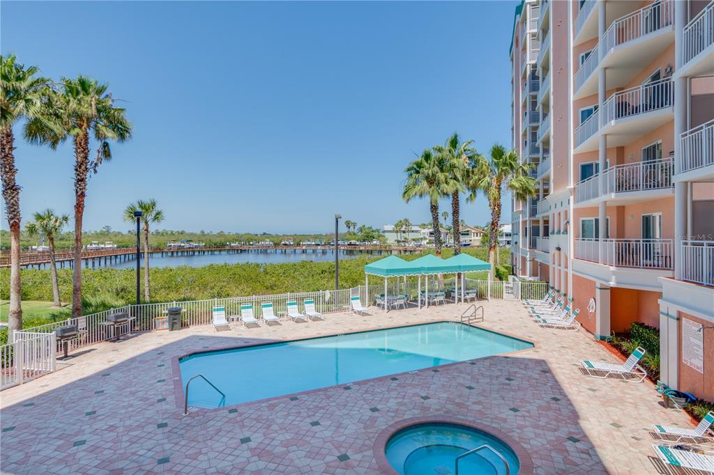 4516 Seagull Drive, Unit 810 New Port Richey, FL 34652 - Photo 10 of 54 a view of a swimming pool with a lawn chairs and a table