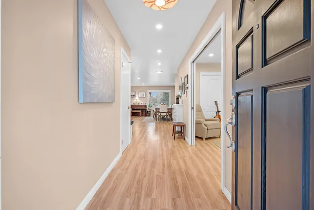 a living room with stainless steel appliances furniture a rug and a kitchen view