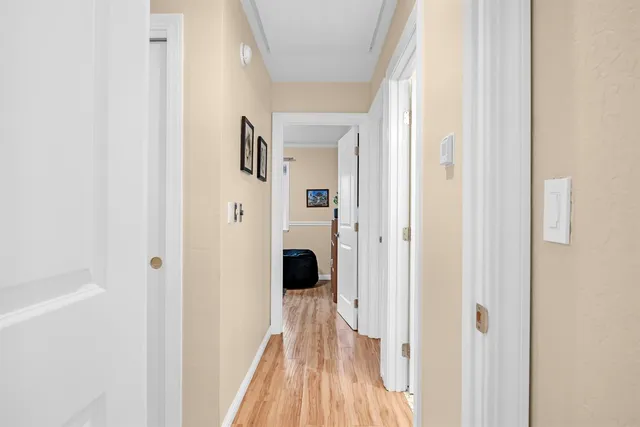 a view of a hallway with wooden floor and staircase