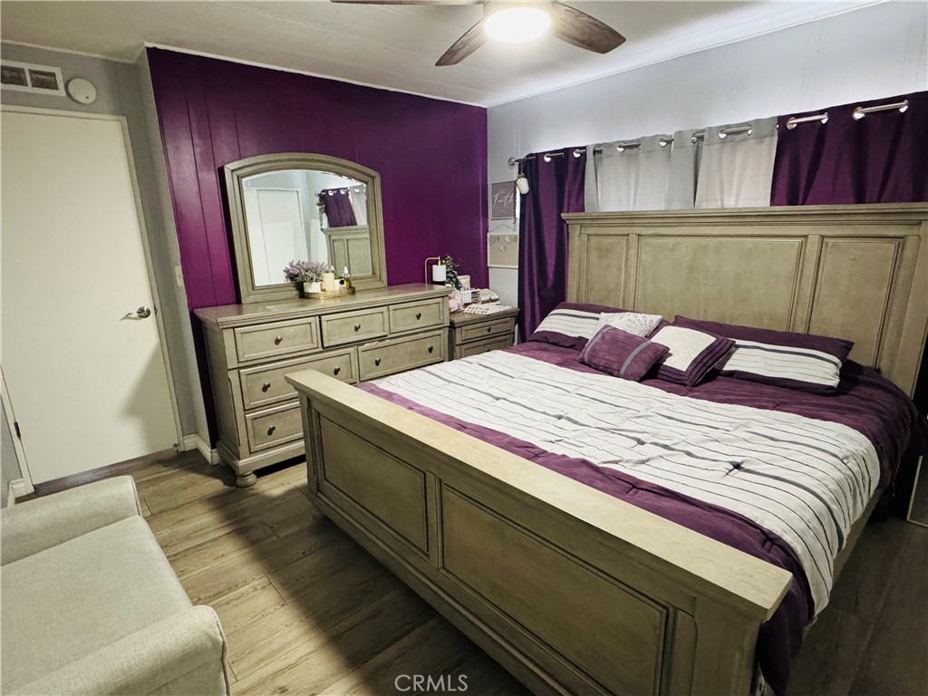 26245 East Baseline Street, Unit 18 Highland, CA 92346 - Photo 14 of 25 a bedroom with a bed and a mirror on dresser