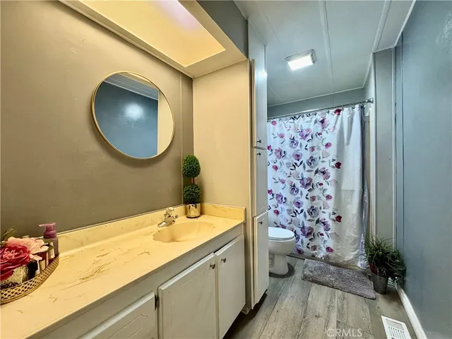 a bathroom with a granite countertop toilet sink and mirror
