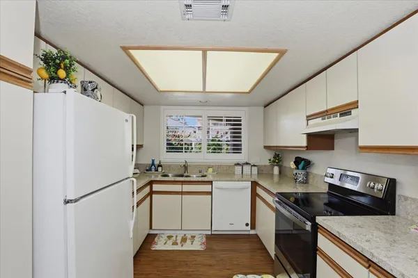 a kitchen with a sink stove top oven and cabinets