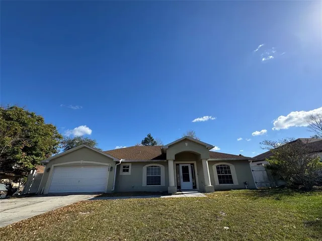 a front view of a house with a garden and yard