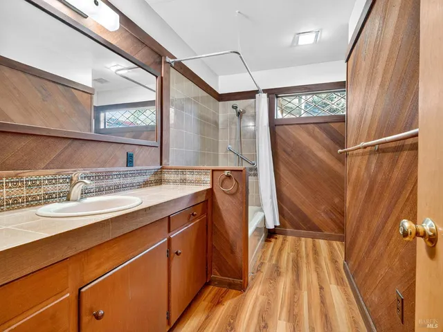 a dining room with wooden floor a chandelier a wooden table and chairs