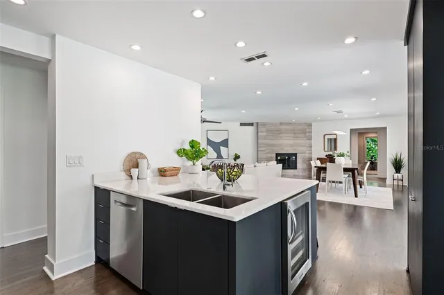 a room with stainless steel appliances kitchen island a table and chairs in it