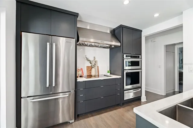 a kitchen with stainless steel appliances granite countertop a refrigerator and a sink