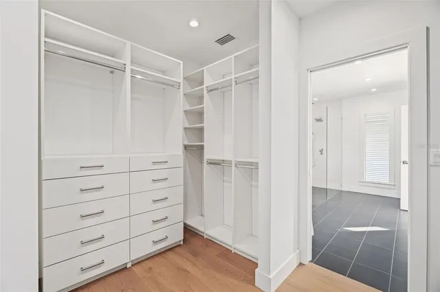 a view of walk in closet with empty racks