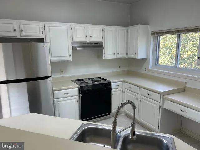 a kitchen with a refrigerator stove and white cabinets