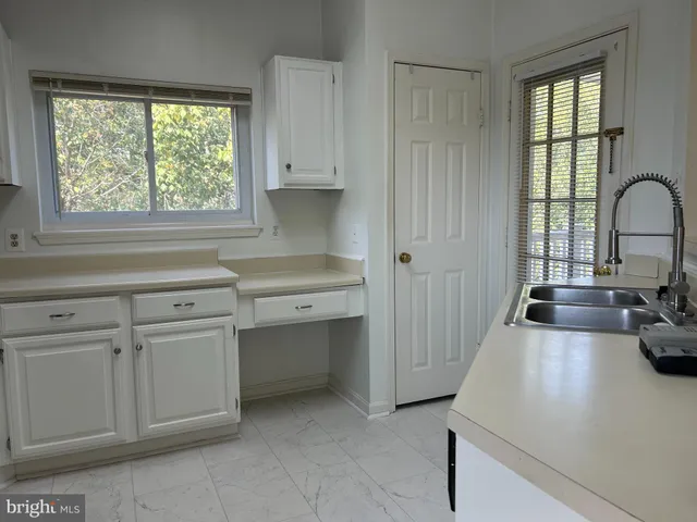 a kitchen with white cabinets and appliances