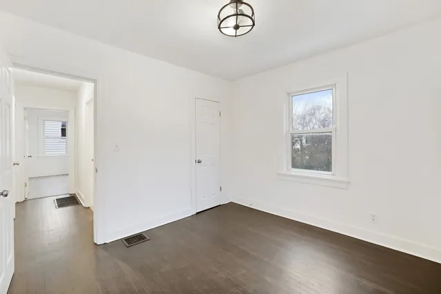 an empty room with a window and a ceiling fan