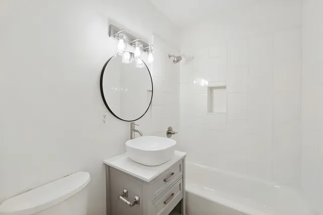a bathroom with a sink a toilet and a mirror