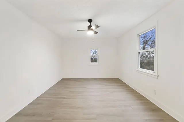 an empty room with windows and cabinet
