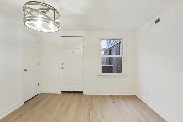 an empty room with a mirror and wooden floor