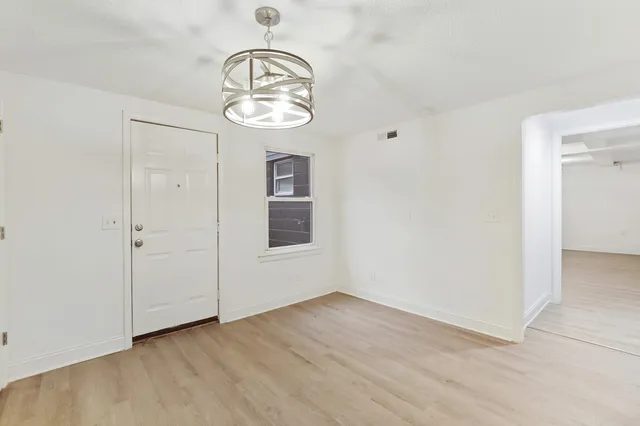 an empty room with wooden floor and mirror