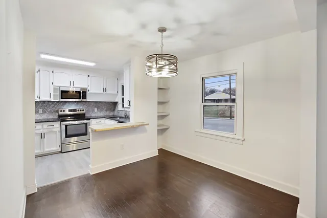 a kitchen with wooden floors and stainless steel appliances