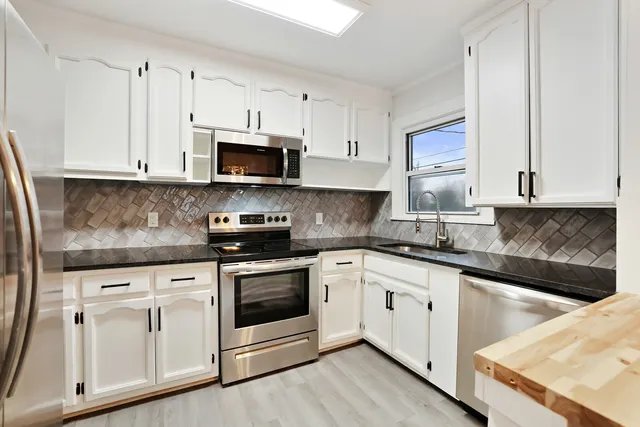 a kitchen with white cabinets and white appliances