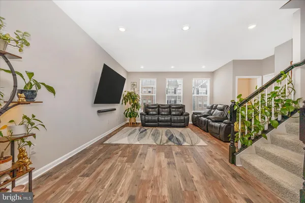 a kitchen with a stove a refrigerator and a dining table with wooden floor