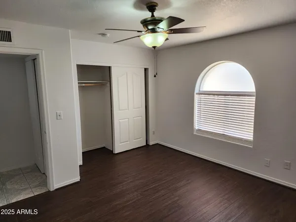 a view of an empty room with a window and wooden floor