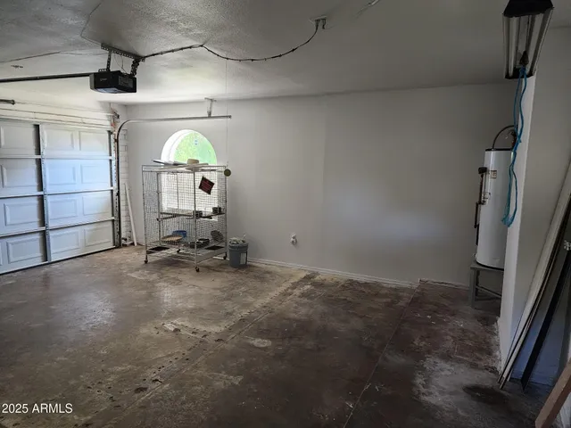 an empty room with wooden floor fan and window