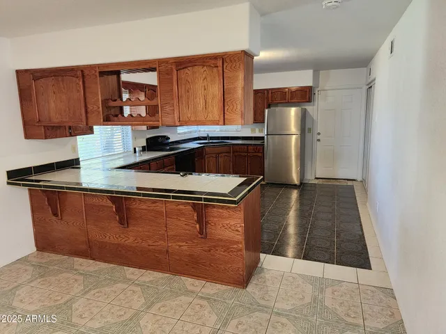 a kitchen with a sink a refrigerator and cabinets