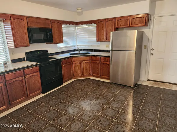 a kitchen with stainless steel appliances granite countertop a refrigerator and a microwave