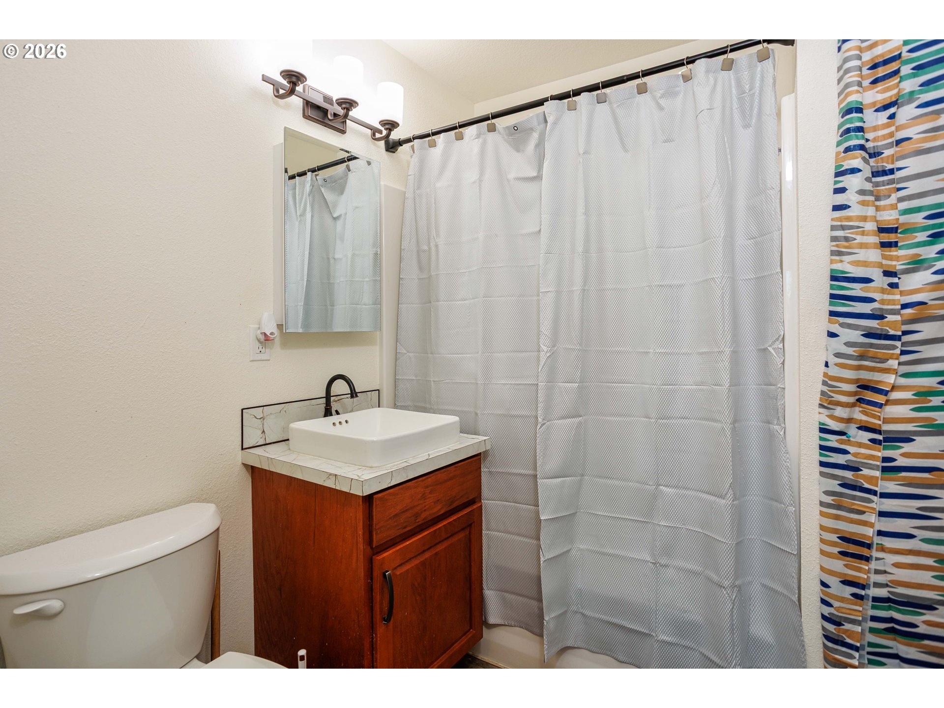 8715 Northeast Clackamas Street Portland, OR 97220 - Photo 16 of 25 a bathroom with a shower curtain and a sink