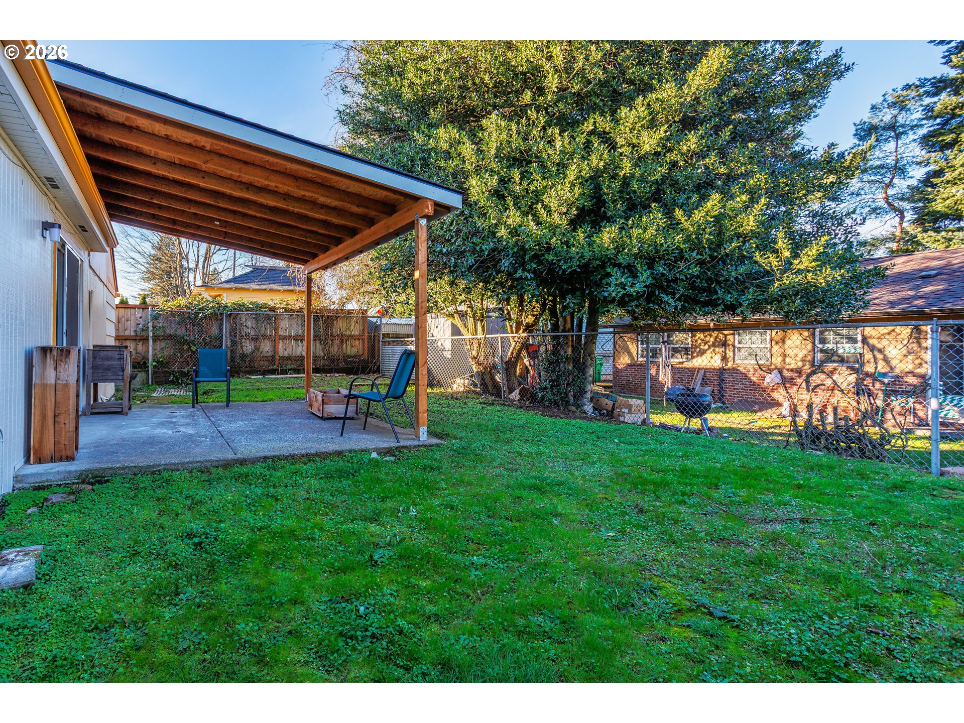 8715 Northeast Clackamas Street Portland, OR 97220 - Photo 23 of 25 a view of a backyard with table and chairs under an umbrella