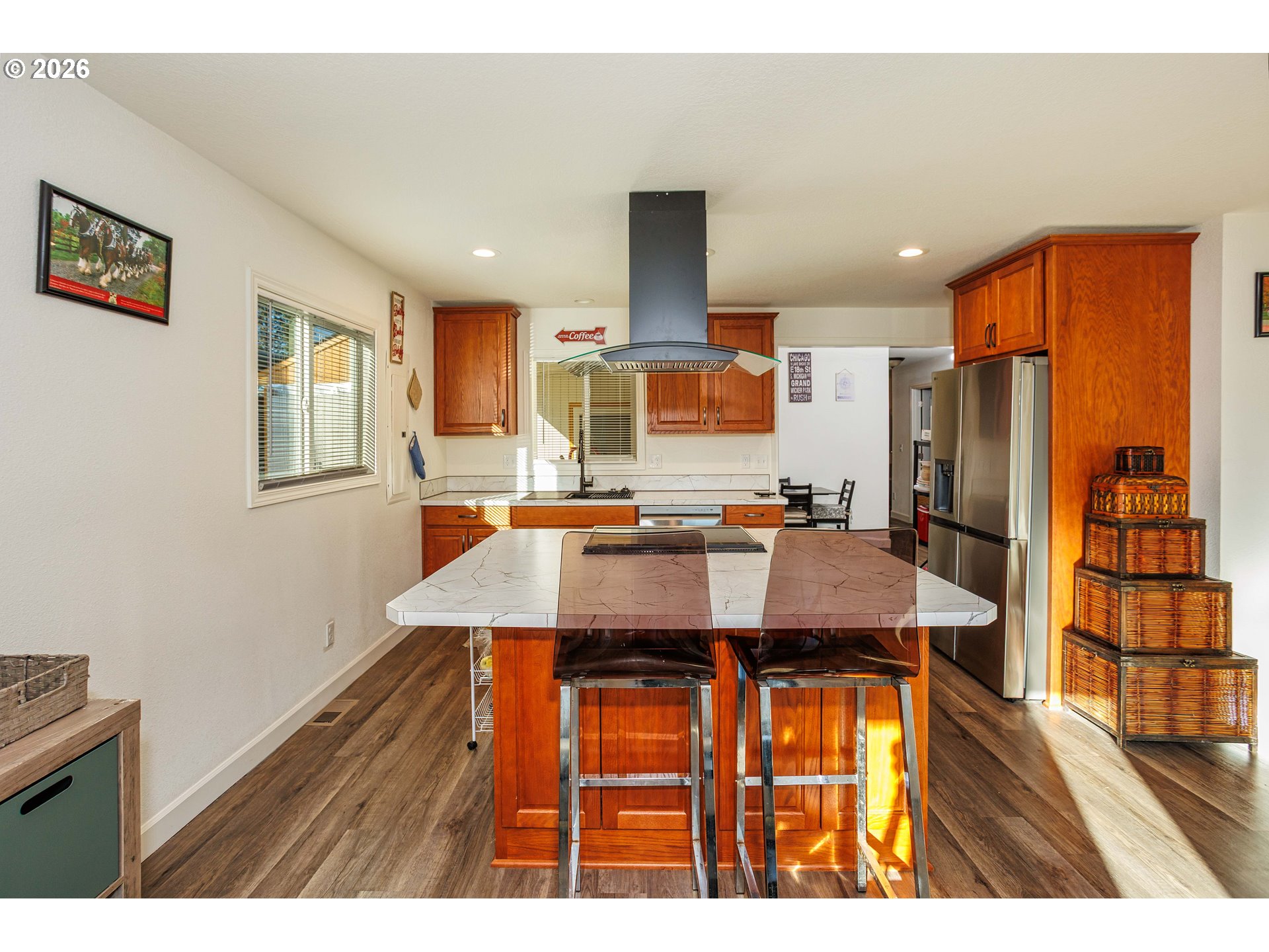 8715 Northeast Clackamas Street Portland, OR 97220 - Photo 7 of 25 a kitchen with stainless steel appliances kitchen island granite countertop a refrigerator a sink a dining table and chairs