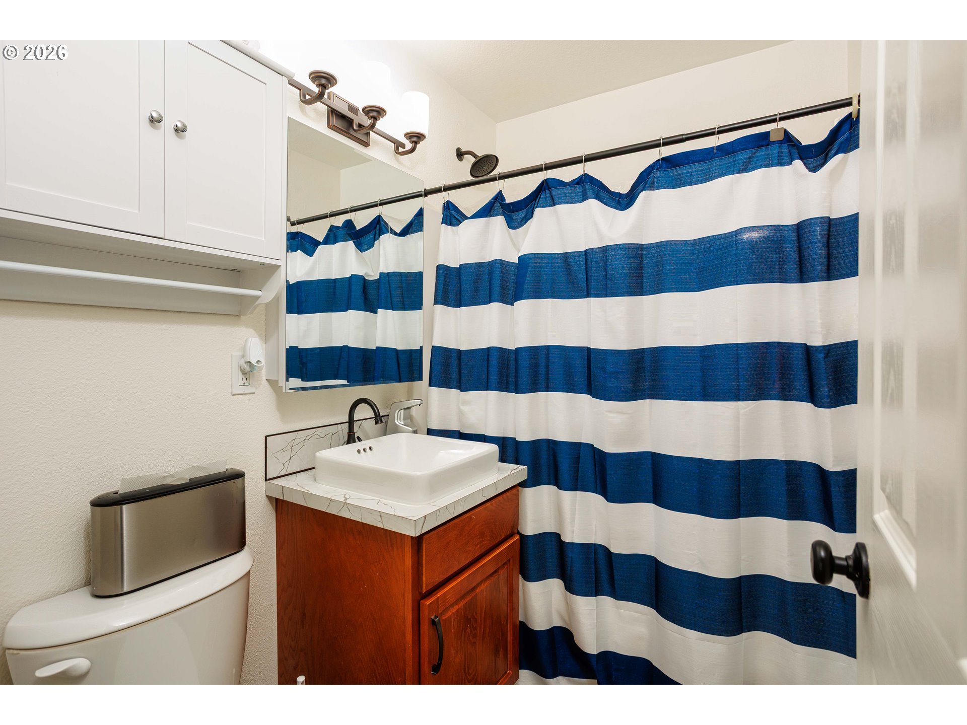 8715 Northeast Clackamas Street Portland, OR 97220 - Photo 10 of 25 a bathroom with a sink a mirror and a shower curtain