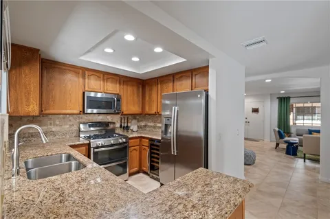 a kitchen with stainless steel appliances granite countertop a sink refrigerator and microwave
