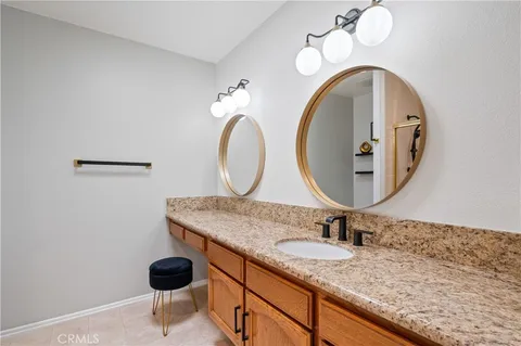 a bathroom with a granite countertop sink and a mirror