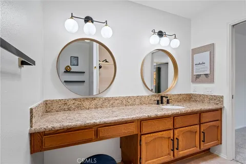 a bathroom with a granite countertop double vanity sink and a mirror