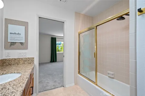 a view of hallway with a granite countertop shower and a sink