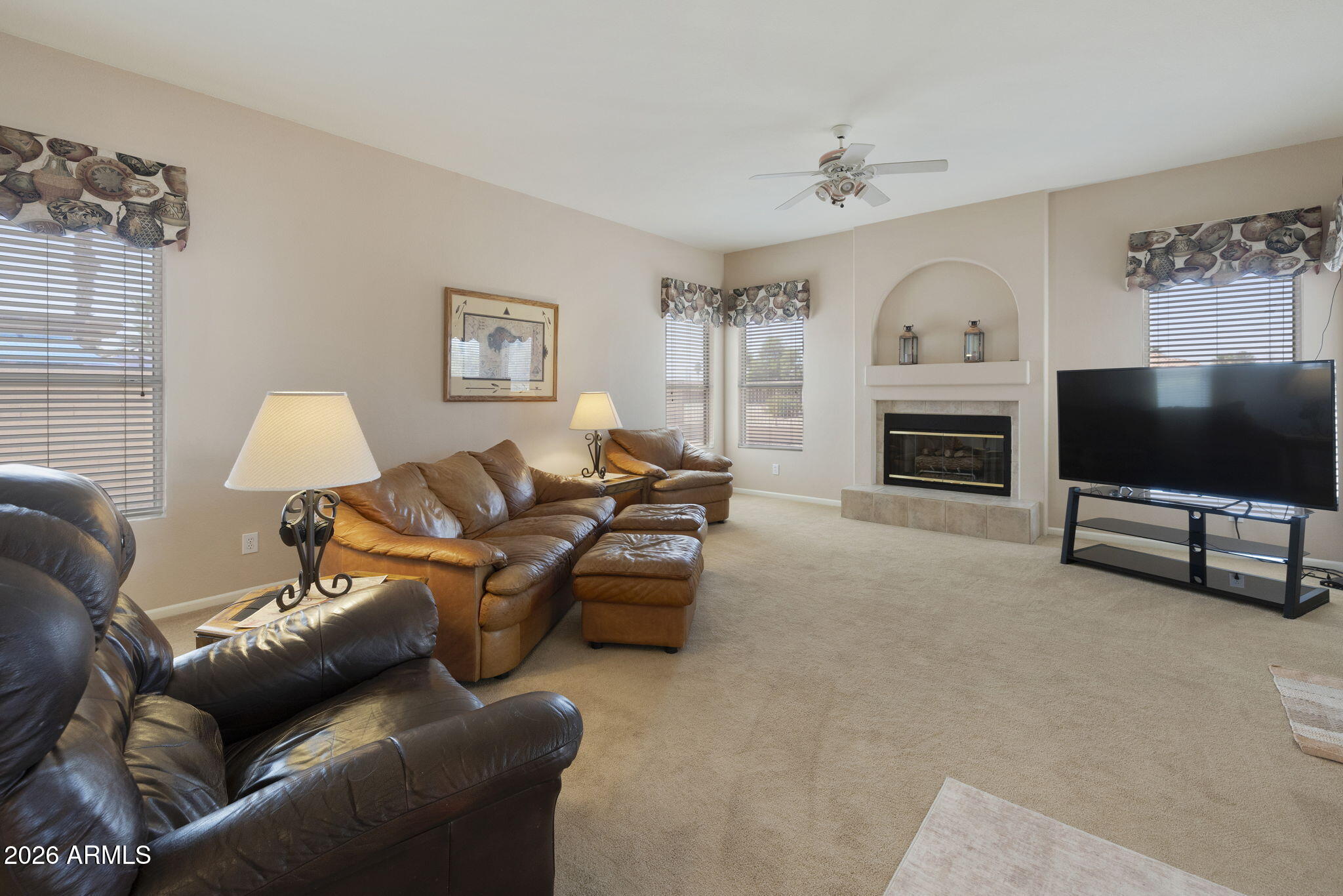 12435 West Monte Vista Road Avondale, AZ 85392 - Photo 25 of 69 a living room with furniture a flat screen tv and a fireplace