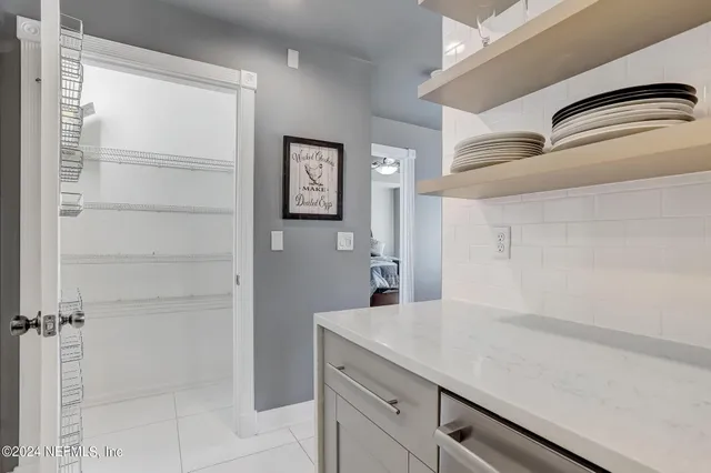 a bedroom with a bed and a lamp on dresser