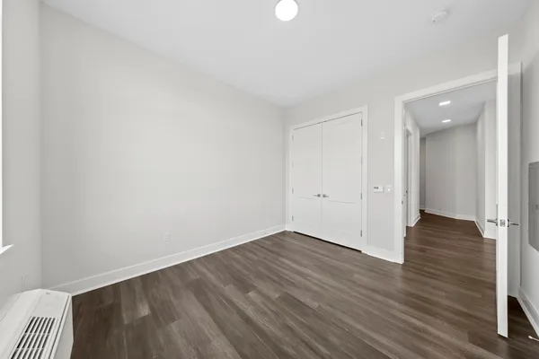 a view of an empty room with wooden floor