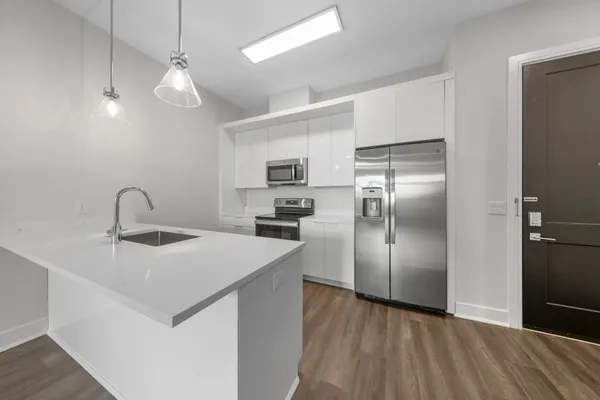 a kitchen with kitchen island a sink stainless steel appliances and refrigerator
