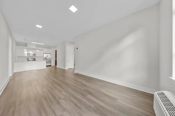 a view of empty room with wooden floor