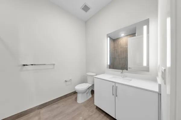 a bathroom with a toilet sink and mirror