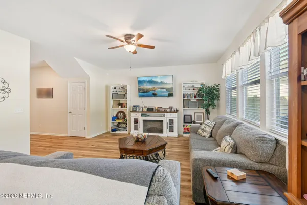 a kitchen with stainless steel appliances granite countertop a refrigerator a sink dishwasher a stove and white cabinets with wooden floor